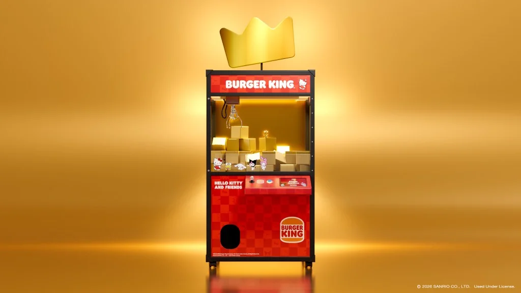 A claw machine featuring a Burger King theme with Hello Kitty and friends plush toys inside, set against a golden background.